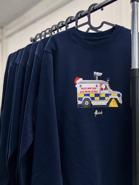 Feliz Navi Yer Da 2026 Christmas jumper by AJ Laird, navy sweatshirt with a festive Meatwagon design